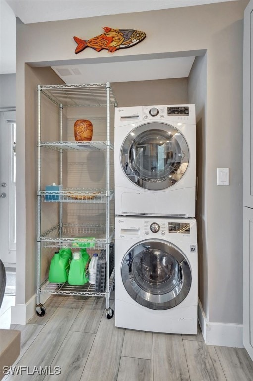 clothes washing area featuring stacked washer / dryer