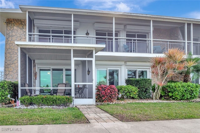 view of front of property with a balcony and a sunroom