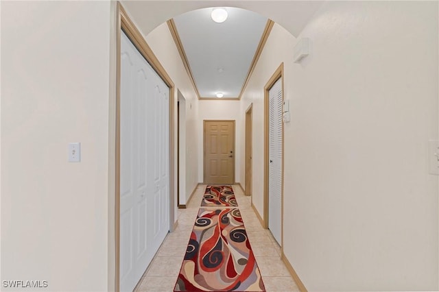 corridor featuring light tile patterned flooring and crown molding