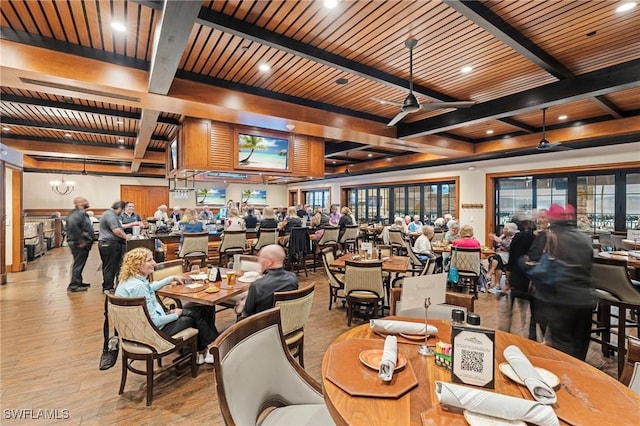 dining space with light wood-style floors, a wealth of natural light, beamed ceiling, and a ceiling fan