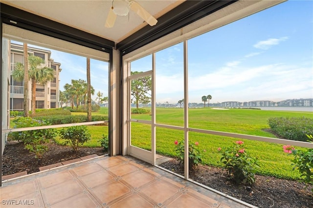 unfurnished sunroom with ceiling fan