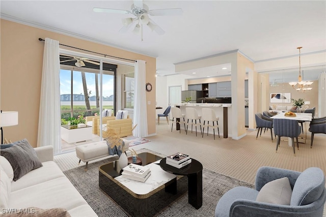 living room featuring ornamental molding, light colored carpet, baseboards, and ceiling fan with notable chandelier