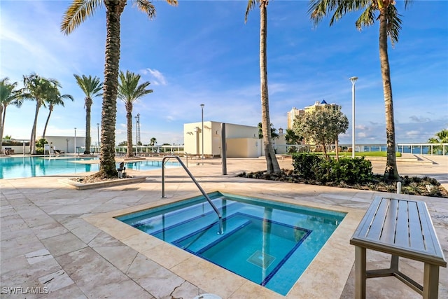 view of swimming pool featuring a patio area and a community hot tub