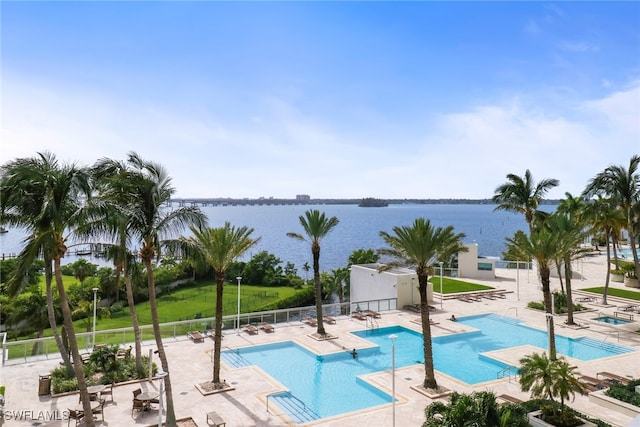 view of pool with a water view and a patio