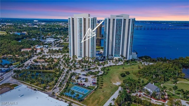 aerial view at dusk featuring a water view