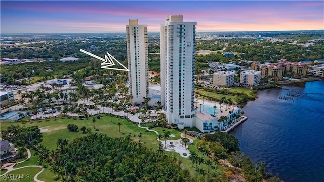 aerial view at dusk featuring a water view