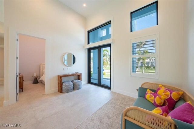 entryway featuring french doors, a towering ceiling, and light tile patterned floors