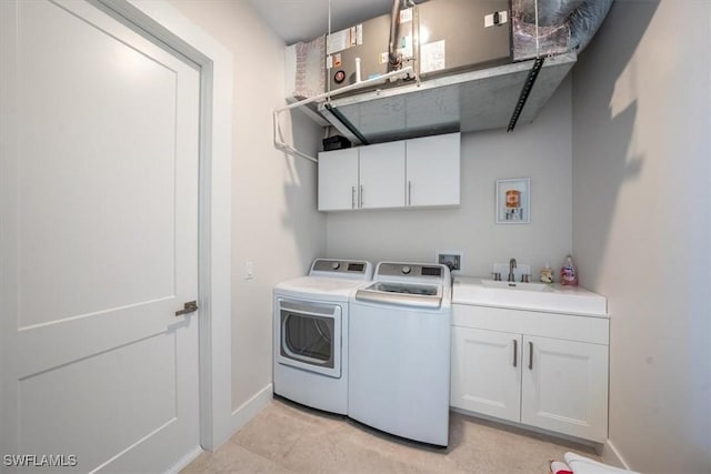 washroom featuring cabinets, independent washer and dryer, and sink