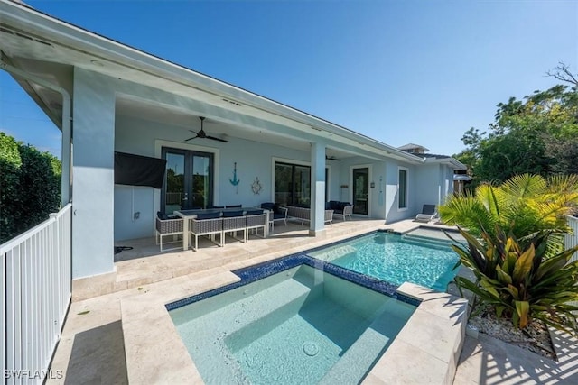 rear view of property featuring french doors, outdoor lounge area, ceiling fan, a swimming pool with hot tub, and a patio area