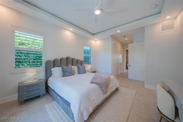 bedroom with ceiling fan and a raised ceiling