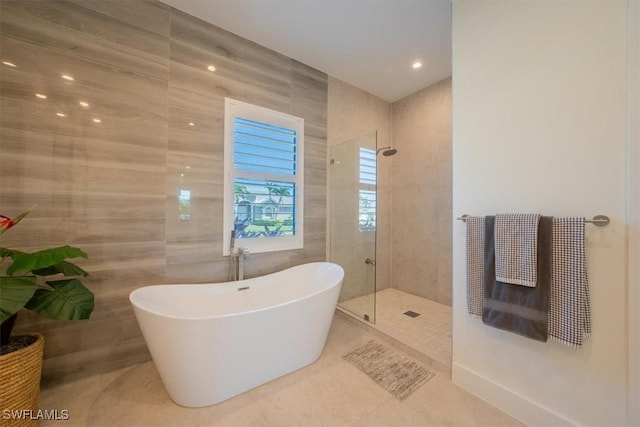 bathroom featuring shower with separate bathtub, tile patterned floors, and tile walls