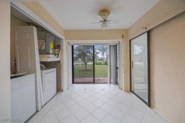 laundry area featuring water heater, ceiling fan, light tile patterned floors, and washer and clothes dryer