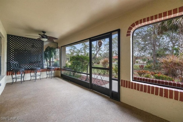 unfurnished sunroom featuring ceiling fan