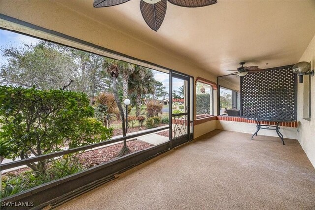 unfurnished sunroom featuring ceiling fan