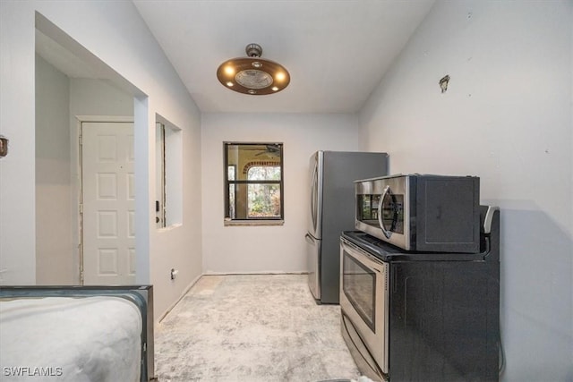 kitchen with stainless steel microwave and light colored carpet