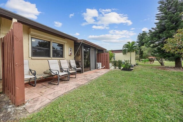 rear view of property with a patio area and a lawn