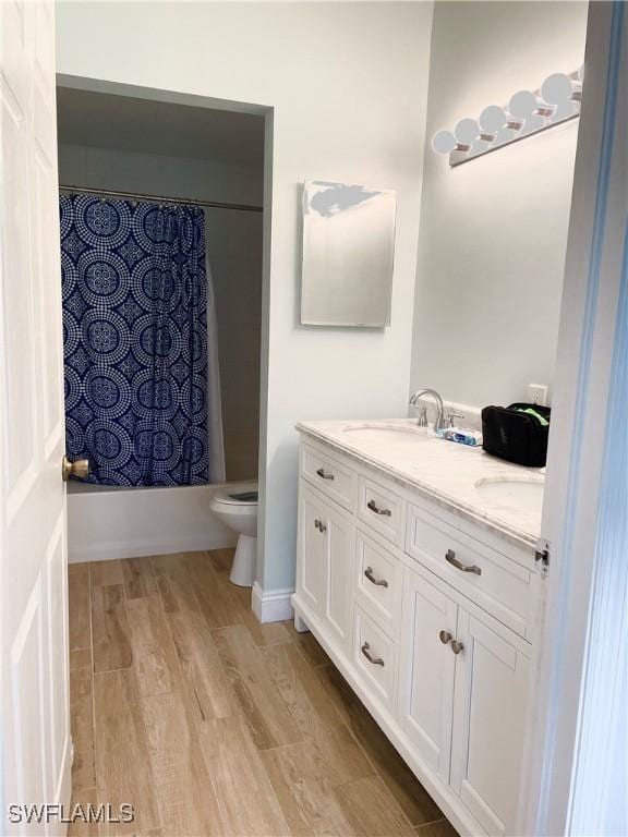 full bathroom with wood-type flooring, vanity, toilet, and shower / bathtub combination with curtain