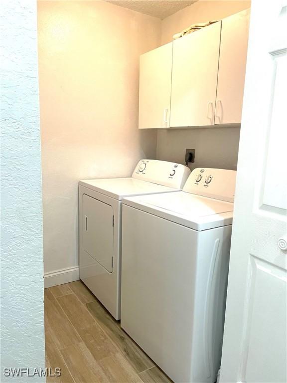 laundry area featuring washer and dryer and cabinets