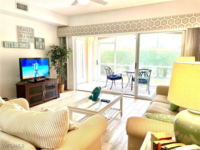 living room featuring ceiling fan and light hardwood / wood-style floors