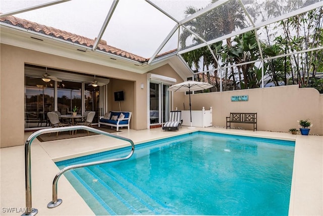 view of swimming pool featuring a patio, ceiling fan, and a lanai