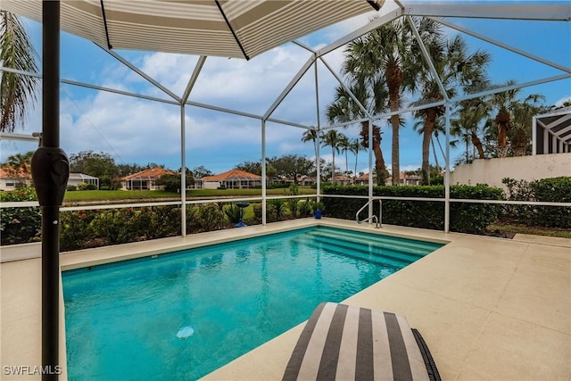 view of pool with glass enclosure and a patio