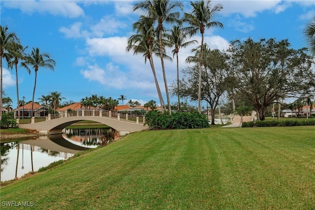 view of home's community featuring a water view and a lawn