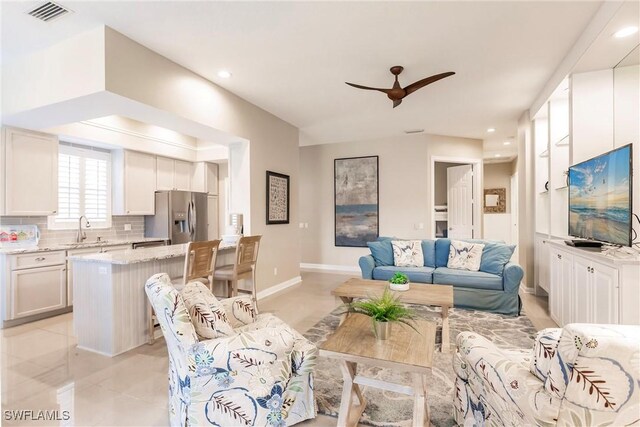 living room featuring ceiling fan and sink