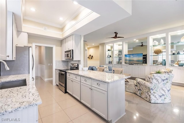 kitchen featuring sink, light stone counters, backsplash, white cabinets, and appliances with stainless steel finishes