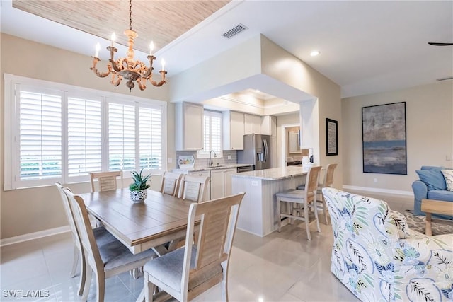 tiled dining area featuring a chandelier and a tray ceiling