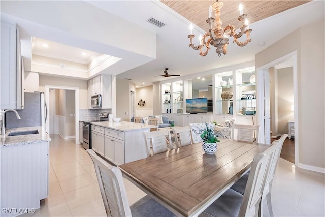 tiled dining space with a raised ceiling, sink, wooden ceiling, and ceiling fan with notable chandelier