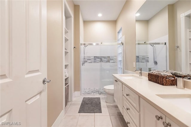 bathroom featuring tile patterned flooring, vanity, toilet, and an enclosed shower