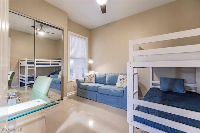 tiled bedroom featuring ceiling fan and a closet