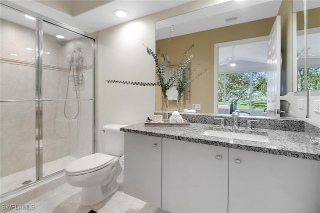 bathroom featuring toilet, an enclosed shower, vanity, ceiling fan, and tile patterned flooring