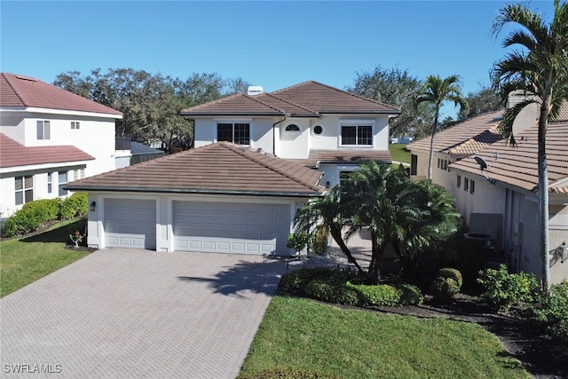 mediterranean / spanish house featuring a garage and a front lawn