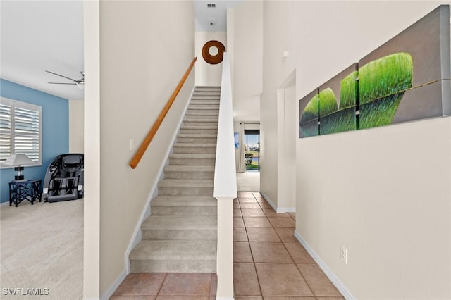 stairway with tile patterned floors and ceiling fan