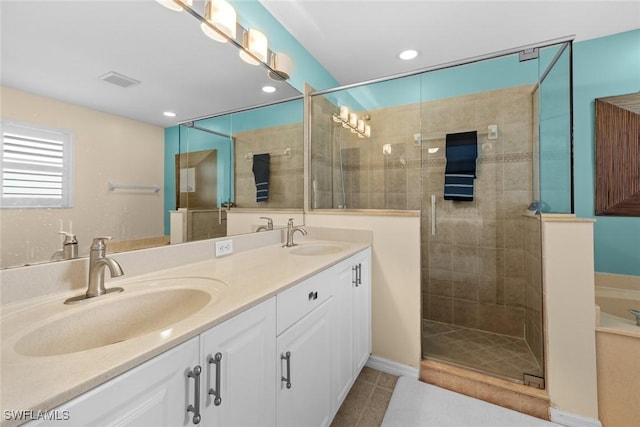 bathroom with tile patterned flooring, vanity, and a shower with door