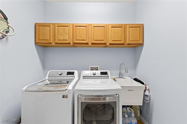 washroom featuring washer and clothes dryer and cabinets