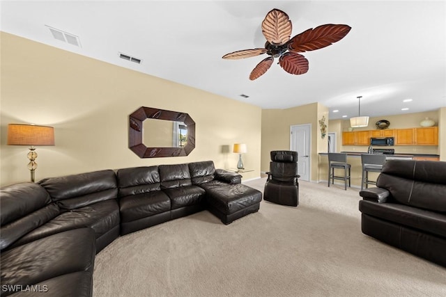 carpeted living room with ceiling fan