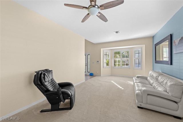 living area featuring light carpet and ceiling fan