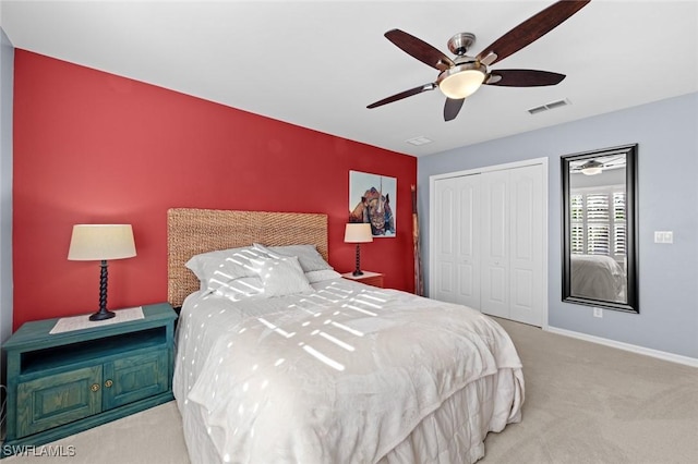 bedroom with ceiling fan, a closet, and light carpet