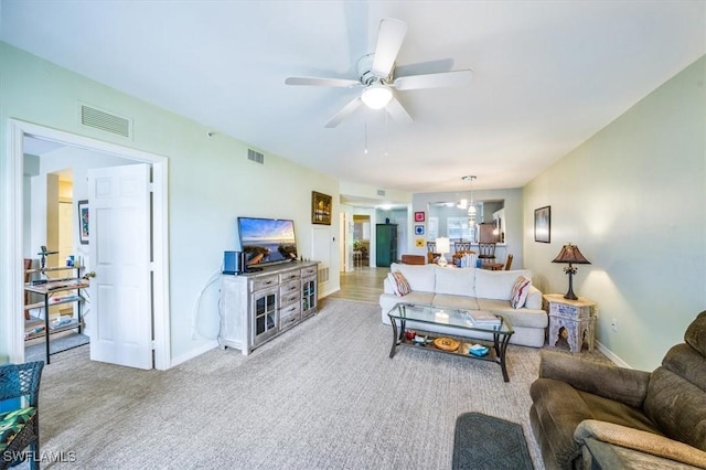 carpeted living room with ceiling fan