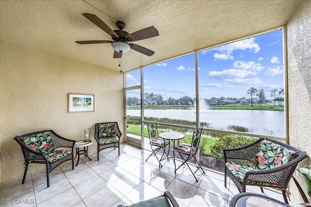 sunroom / solarium featuring ceiling fan, a water view, and a wealth of natural light