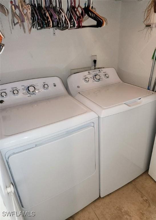 clothes washing area featuring light tile patterned flooring and independent washer and dryer