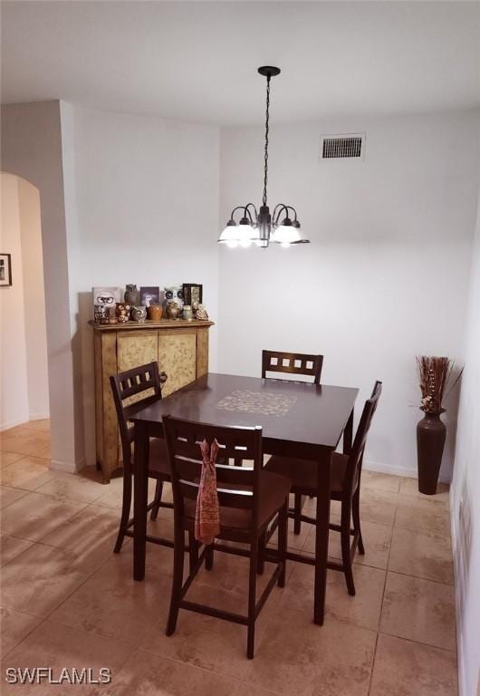 dining space with tile patterned floors and an inviting chandelier