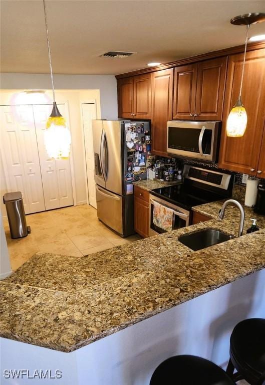 kitchen with kitchen peninsula, decorative light fixtures, and stainless steel appliances