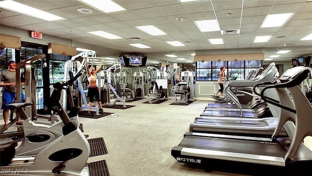 exercise room with a paneled ceiling and carpet