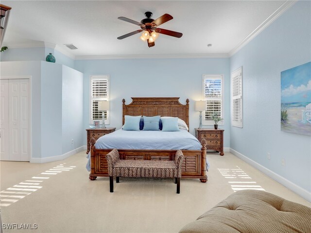 carpeted bedroom featuring a closet, ceiling fan, and crown molding