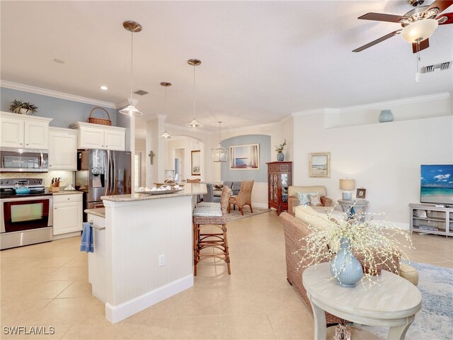 kitchen with decorative light fixtures, white cabinetry, crown molding, and appliances with stainless steel finishes