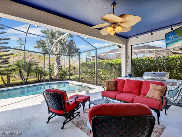 view of patio / terrace with a lanai, an outdoor hangout area, and exterior kitchen