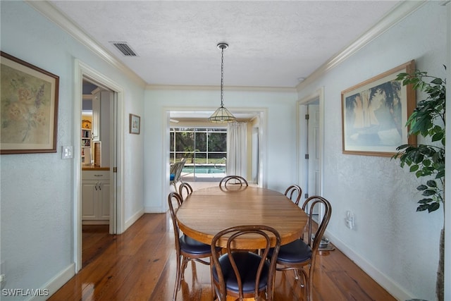 dining room featuring a textured ceiling, dark hardwood / wood-style floors, and crown molding